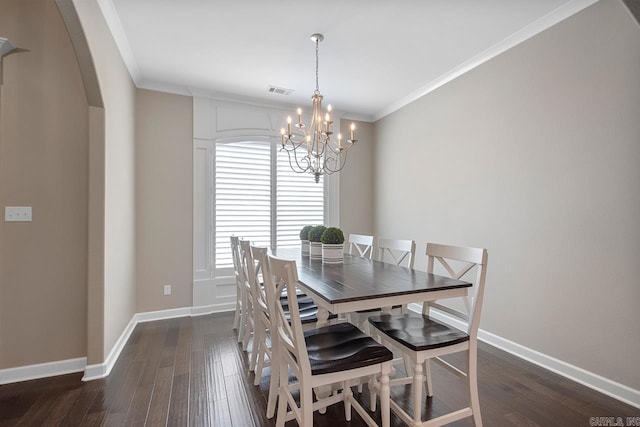 dining area with ornamental molding, dark wood finished floors, arched walkways, baseboards, and a chandelier