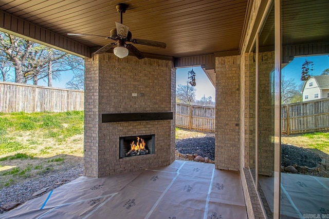 view of patio / terrace with fence, an outdoor brick fireplace, and ceiling fan