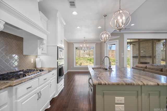 kitchen with visible vents, a notable chandelier, a sink, light stone counters, and stainless steel appliances