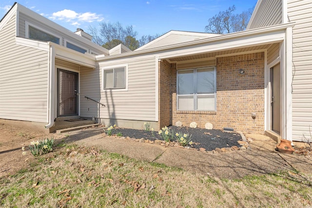 doorway to property featuring brick siding