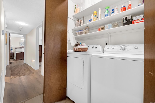 laundry room with washing machine and clothes dryer, laundry area, and light wood-type flooring