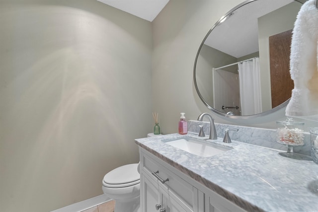 bathroom featuring vanity, a shower with shower curtain, baseboards, tile patterned flooring, and toilet