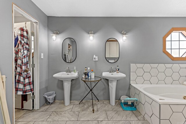 bathroom featuring a sink and a garden tub