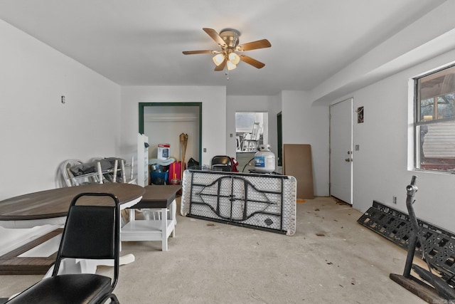 dining space with unfinished concrete flooring and a ceiling fan