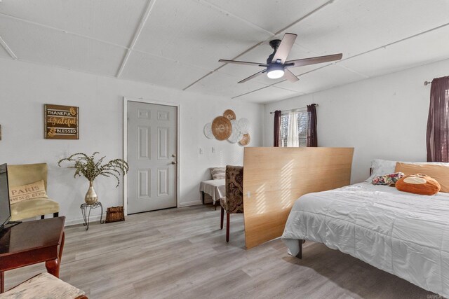 bedroom featuring a ceiling fan, baseboards, and light wood-type flooring