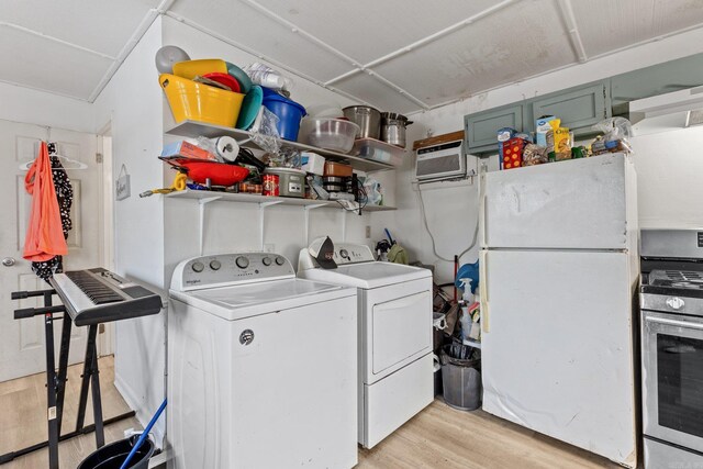 clothes washing area with laundry area, a wall unit AC, light wood-style floors, and independent washer and dryer