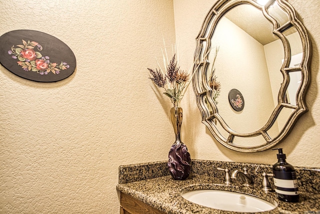 bathroom featuring vanity and a textured wall