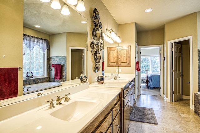 full bathroom with plenty of natural light, a textured ceiling, ensuite bath, and vanity