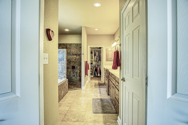 full bathroom featuring a spacious closet, a garden tub, recessed lighting, a stall shower, and vanity