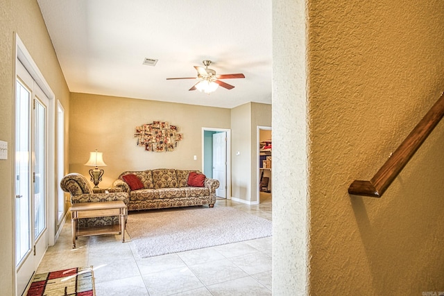 living area featuring a wealth of natural light, visible vents, ceiling fan, and light tile patterned flooring