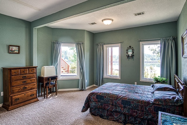 bedroom with visible vents, a textured ceiling, baseboards, and carpet floors