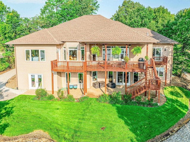 rear view of property featuring a shingled roof, stairway, a lawn, french doors, and a patio