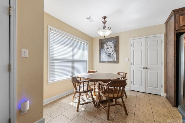 dining room with light tile patterned floors, visible vents, and baseboards