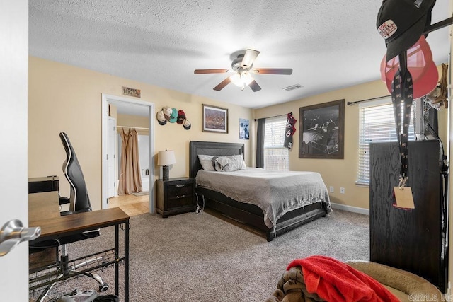 bedroom featuring multiple windows, carpet, and a textured ceiling