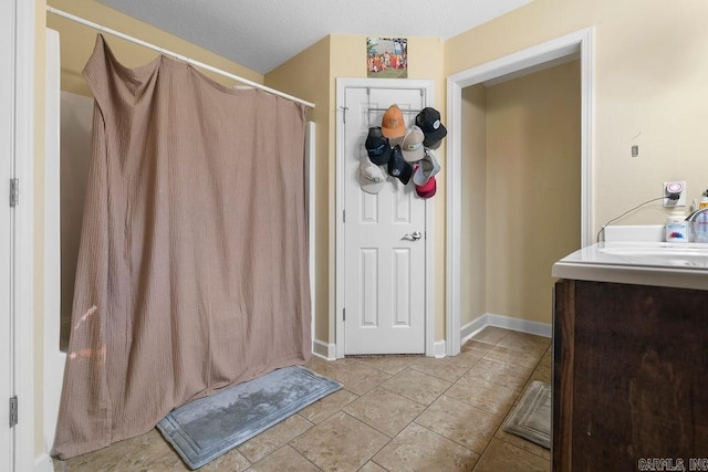 full bathroom with a sink, baseboards, a shower with curtain, and tile patterned floors