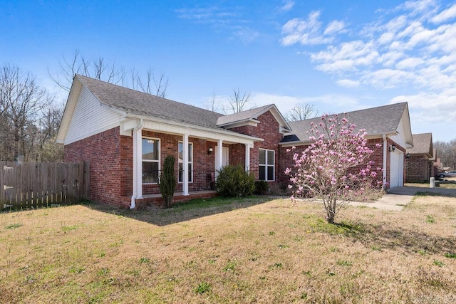 view of front of property featuring a front lawn, a garage, fence, and brick siding