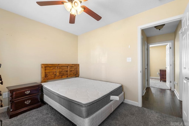 bedroom with dark colored carpet, baseboards, and a ceiling fan