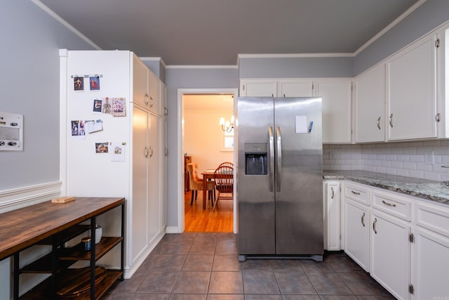 kitchen featuring backsplash, crown molding, stainless steel fridge with ice dispenser, dark tile patterned floors, and white cabinets