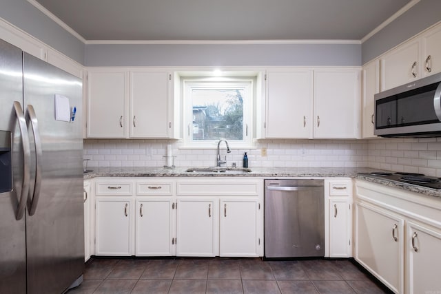 kitchen with ornamental molding, a sink, white cabinets, appliances with stainless steel finishes, and tasteful backsplash