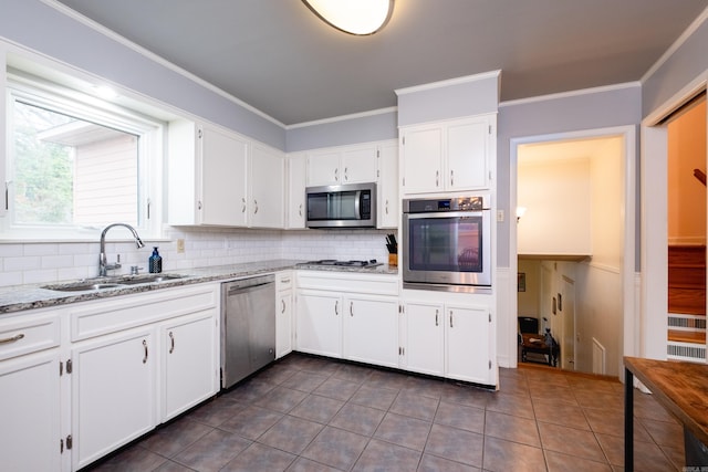 kitchen featuring a sink, tasteful backsplash, white cabinetry, and stainless steel appliances