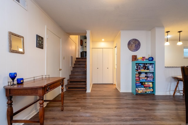 interior space with stairway, dark wood-type flooring, visible vents, and crown molding