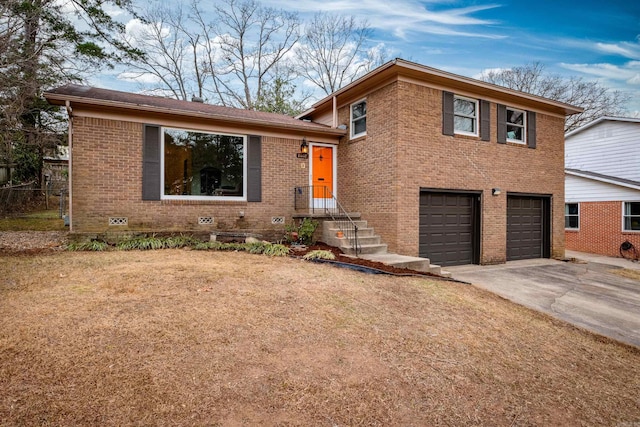 split level home with concrete driveway, a garage, brick siding, and a front yard