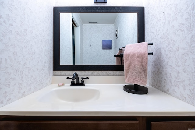 bathroom featuring wallpapered walls, vanity, and visible vents