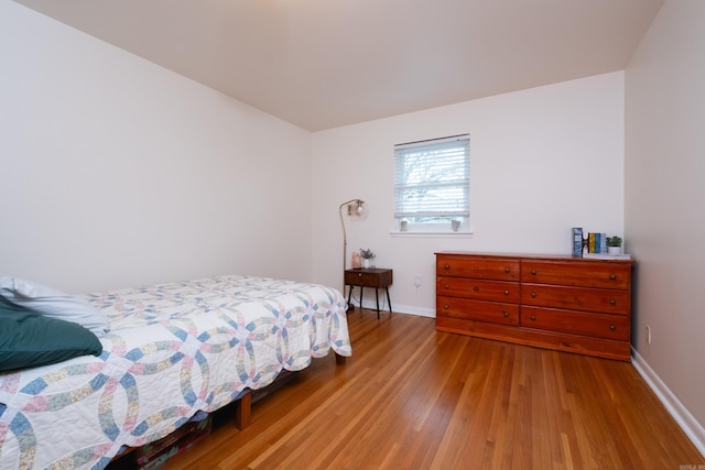 bedroom featuring baseboards and wood finished floors