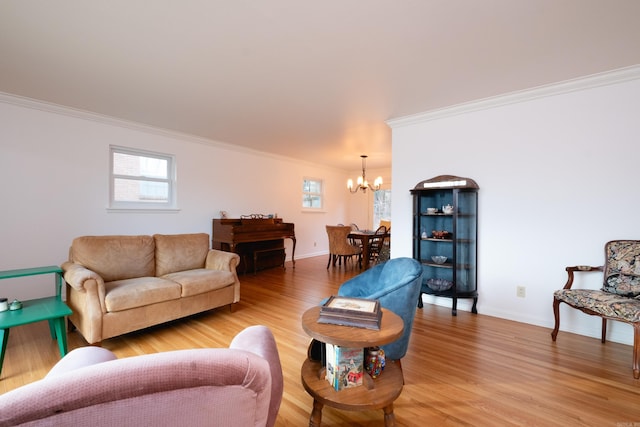 living room with ornamental molding, baseboards, light wood finished floors, and a chandelier