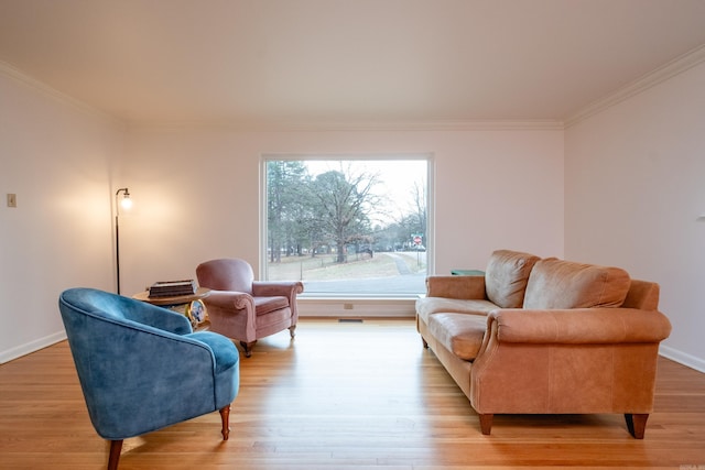 living area featuring crown molding, light wood-type flooring, and baseboards