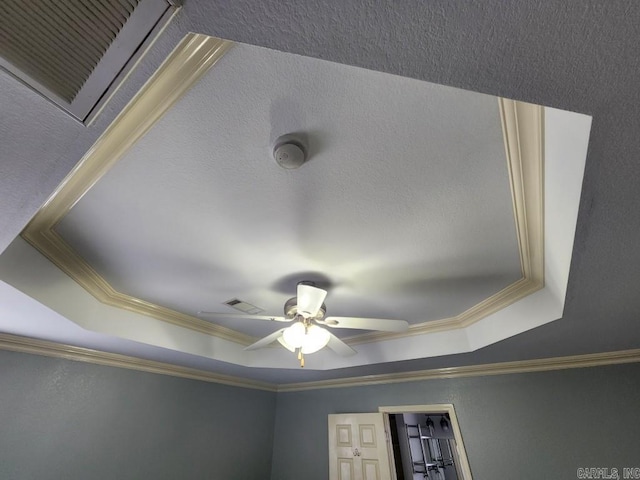 details featuring ceiling fan, a tray ceiling, visible vents, and ornamental molding