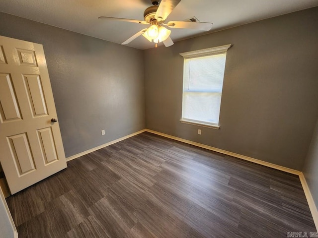 empty room featuring baseboards, dark wood finished floors, and a ceiling fan