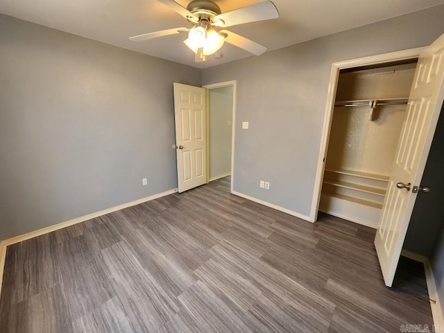 unfurnished bedroom with a closet, ceiling fan, dark wood-type flooring, and baseboards