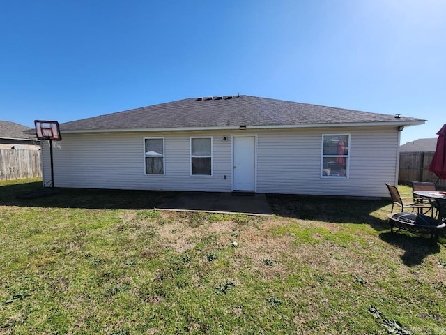 back of property featuring a patio, a fire pit, a lawn, and fence