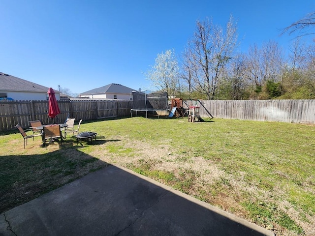 view of yard with a trampoline and a fenced backyard