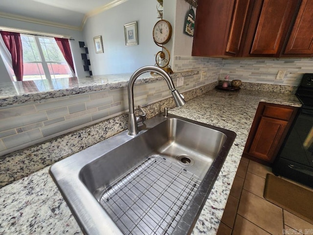 room details featuring tasteful backsplash, a sink, crown molding, light stone countertops, and range