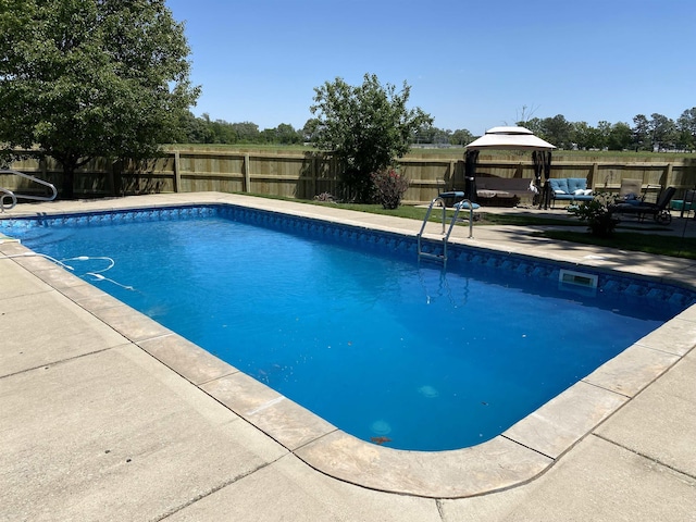 view of pool featuring a gazebo, a fenced backyard, a fenced in pool, and a patio area