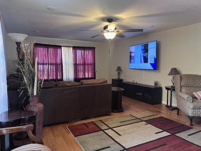 living area featuring ceiling fan and wood finished floors