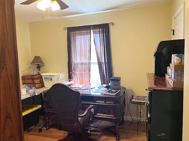 office area featuring wood finished floors, a ceiling fan, baseboards, and ornamental molding