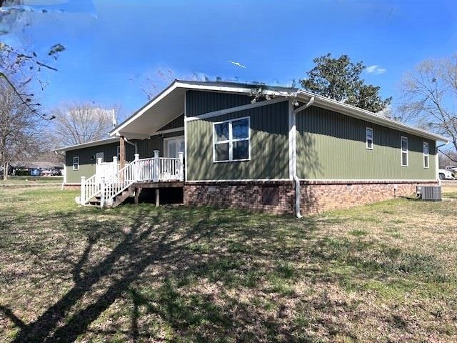 view of home's exterior featuring central air condition unit and a lawn