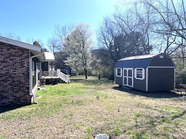 view of yard with an outdoor structure, a shed, and a wooden deck