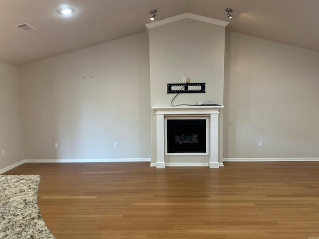 unfurnished living room featuring visible vents, baseboards, lofted ceiling, a fireplace, and light wood-style floors