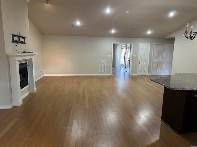 unfurnished living room with visible vents, recessed lighting, a fireplace, light wood finished floors, and baseboards