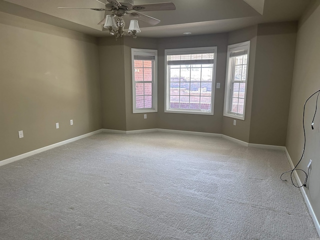 spare room with a ceiling fan, carpet, a healthy amount of sunlight, and baseboards