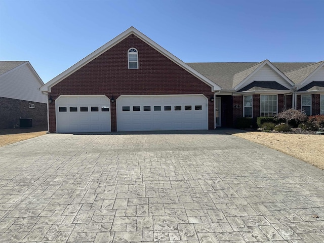 view of front facade featuring brick siding and decorative driveway