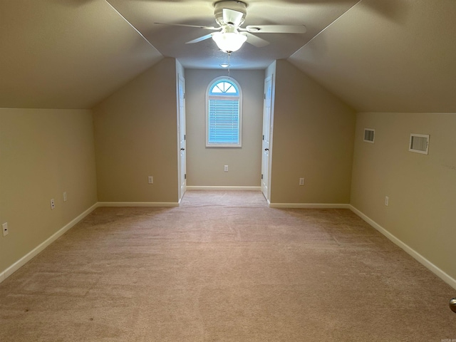 bonus room featuring visible vents, light carpet, lofted ceiling, a ceiling fan, and baseboards