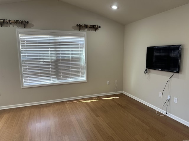 unfurnished living room featuring baseboards, lofted ceiling, a healthy amount of sunlight, and wood finished floors