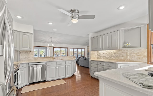 kitchen featuring a wealth of natural light, ceiling fan with notable chandelier, stainless steel appliances, and a sink