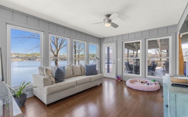 sunroom with a ceiling fan, a water view, and a healthy amount of sunlight