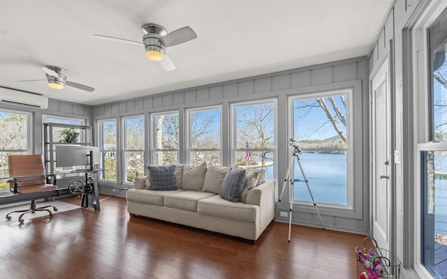 sunroom / solarium with a wall mounted AC, a ceiling fan, and a water view